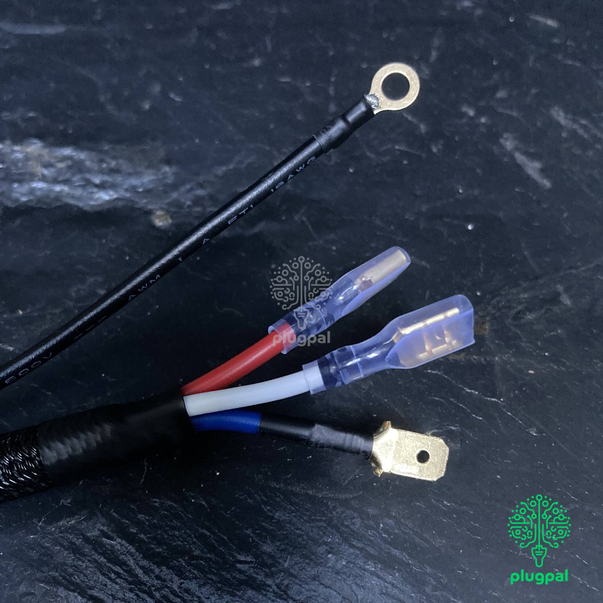 Brake Light Pressure Switch Relay - Close-up image of electrical wiring with insulated connectors and a ring terminal, showing detailed connections on a dark surface.