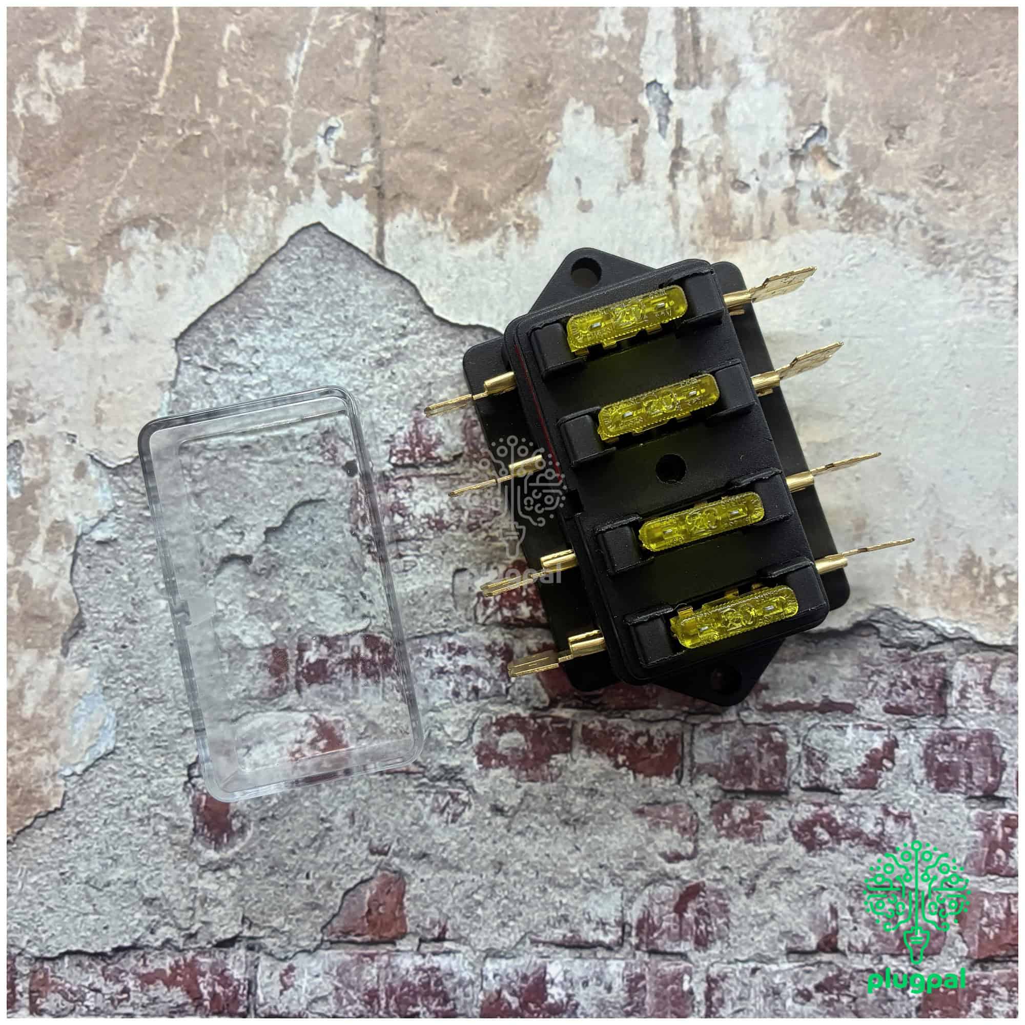 Close-up of a blade fuse box with four yellow LED fuses and metal prongs, used in automotive electrical systems.