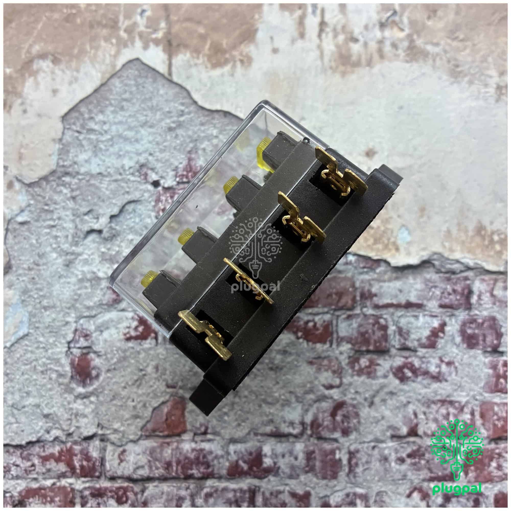 Close-up of MG blade fuse box with multiple blade fuses and gold connectors, suitable for vehicle electrical systems.